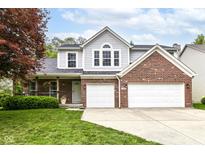 Charming two-story home boasts brick and gray siding, a well-manicured lawn, and a convenient two-car garage at 11193 Harriston Dr, Fishers, IN 46037