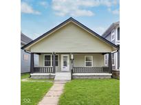 Charming bungalow with a covered front porch, black trim, and a well-maintained lawn at 906 N Parker Ave, Indianapolis, IN 46201