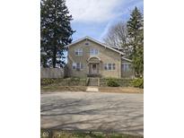 Attractive two-story home with stone exterior, steps leading to the front door, and mature trees at 927 E Southern Ave, Indianapolis, IN 46203