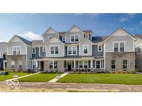 Charming townhome showcases gray siding, stone accents, and a well-manicured lawn at 5743 Cr W 750 N, McCordsville, IN 46055
