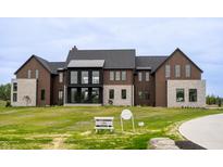 Beautiful modern home with a well-manicured front lawn and attractive mixed material facade at 9700 Windy Hills Dr, Zionsville, IN 46077