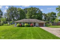 Charming single-story home featuring a well-maintained lawn, colorful bushes, and an attached one-car garage at 105 Tulip Dr, Indianapolis, IN 46227