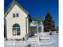 Charming two-story house with a green roof and snow-covered yard at 902 W Main St, Greenfield, IN 46140