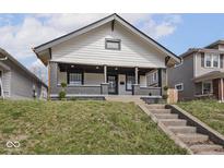 Charming two-story home featuring a covered porch and professionally landscaped front yard at 1210 Finley Ave, Indianapolis, IN 46203