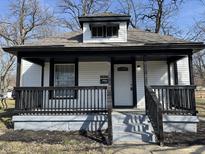 Charming home features a covered front porch with black railings and updated facade at 2869 Stuart St, Indianapolis, IN 46218