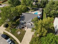 Aerial view of a two-story home with a pool, basketball court, and mature trees at 1121 Ebony Ln, Franklin, IN 46131