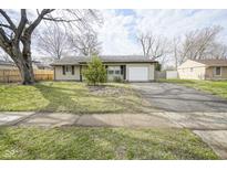 Charming home featuring a well-maintained lawn and an attached garage at 5945 Gateway Dr, Indianapolis, IN 46254