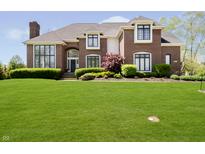 Stunning brick home with manicured lawn and lush landscaping at 13668 Cheswick Blvd, Carmel, IN 46032