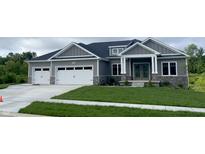 Charming gray home featuring a well-manicured lawn, stone accents, and a three-car garage at 3725 Maple Ridge Trl, Columbus, IN 47201