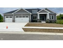 Charming single-story home with gray siding, stone accents, and a three-car garage at 3725 Maple Ridge Trl, Columbus, IN 47201