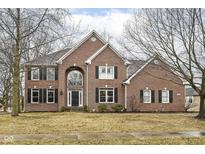 Charming two-story brick home featuring black shutters, arched window, and well-manicured lawn at 14626 Warner Trl, Westfield, IN 46074
