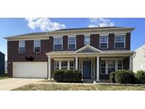 Charming two-story brick home featuring a well-maintained front yard and an attached two-car garage at 5656 Buck Dr, Noblesville, IN 46062