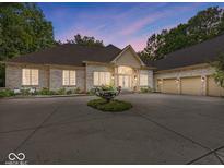 Stunning brick home featuring a circular driveway and three-car garage at 9943 Irishman'S Run Ln, Zionsville, IN 46077