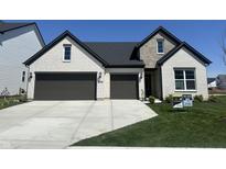 Charming two-story home boasts a white brick facade, stone accents, a dark roof, and a two-car garage at 4982 Reavie Ct, Noblesville, IN 46062