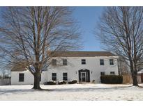 Two-story painted brick house with a dark roof and front door, set against a clear blue sky and snowy lawn at 5429 Channing Rd, Indianapolis, IN 46226