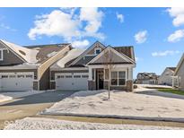 Charming gray home featuring a two-car garage and stone accents, set in a snowy landscape at 16920 Cattle Hollow Ln, Noblesville, IN 46060