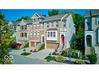 Charming townhomes with attached garages and landscaped front yards create curb appeal at 729 Greenford N Trl, Carmel, IN 46032