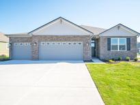 Charming, single-story brick home with a spacious three-car garage and a well-manicured lawn at 231 Lar Lan Dr, Danville, IN 46122