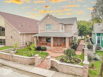 Charming brick home showcasing a well-manicured front yard, inviting front porch, and warm, classic architecture at 1817 Bellefontaine St, Indianapolis, IN 46202