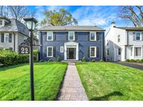 Charming two-story home with a brick facade, black shutters, manicured lawn, and inviting walkway at 22 W 54Th St, Indianapolis, IN 46208