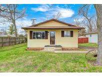 Charming single-story home featuring a yellow exterior, brown shutters, and a well-maintained front yard at 120 Hugo St, Indianapolis, IN 46229