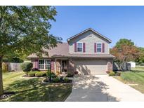 Charming two-story home with a brick and vinyl exterior, landscaped yard and attached two car garage at 7168 Burlat Ln, Noblesville, IN 46062