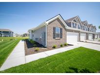 Charming townhome featuring a brick facade, well-manicured lawn, and attached garage at 6272 Wasco Dr, Whitestown, IN 46075