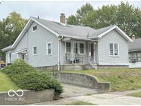 Charming single-Gathering home with light gray siding, a quaint porch and a chimney at 240 W 37Th St, Anderson, IN 46013