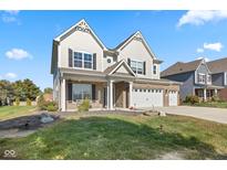 Charming two-story home featuring brick accents, white trim, a manicured lawn, and a three car attached garage at 1220 Greenwood Station Blvd, Greenwood, IN 46143
