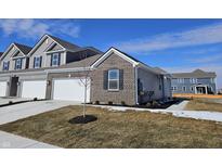 Charming new construction home featuring a brick facade, white garage door and professionally landscaped front yard at 6330 Wasco Dr, Whitestown, IN 46075