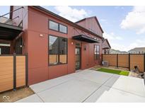 A modern rust-colored home featuring a patio and privacy fence at 1676 Solebar Way, Westfield, IN 46074