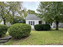 A quaint one-story house featuring black shutters, manicured landscaping, and a well-maintained lawn at 153 S 7Th Ave, Beech Grove, IN 46107