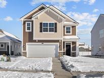 Charming two-story home featuring a two-car garage, classic brown siding, and a snow-covered front yard at 5143 Rolling Meadow Blvd, Indianapolis, IN 46237