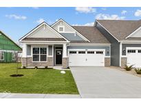 Charming home featuring a two-car garage, stone accents, manicured lawn, and a welcoming front porch at 3544 Wrangler Dr, Bargersville, IN 46106