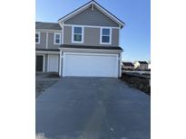 Charming two-story home featuring neutral siding, a spacious two-car garage, and a concrete driveway at 10827 Penwell Way, Indianapolis, IN 46235