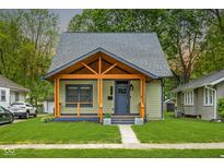 Charming home featuring a custom wood porch, beautiful lawn and inviting curb appeal at 6129 Crittenden Ave, Indianapolis, IN 46220