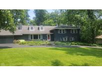 Charming two-story home featuring a beautifully landscaped front yard and a classic architectural design at 6205 Bramshaw Rd, Indianapolis, IN 46220
