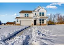 Two-story white house with brown roof, brick accents, and a snow-covered driveway at 300 N Bur Oak Dr, Mooresville, IN 46158