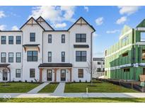 Charming new construction townhome with a white exterior, dark trim, and a well-manicured lawn at 4191 Barrel Ln, Westfield, IN 46062