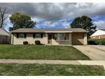 Charming single-story home with well-maintained lawn and attached garage at 1406 Biloxi Ln, Beech Grove, IN 46107