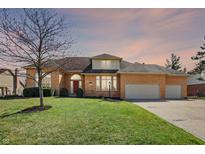 Charming brick home featuring a spacious lawn and three-car garage at 3719 Carwinion Way, Carmel, IN 46032