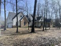 Two-story farmhouse with brick and white siding, gray roof, and attached garage at 4429 Village Dr, Anderson, IN 46012