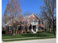 Elegant two-story red brick home featuring a charming front balcony and a well-manicured lawn at 801 Silverleaf Dr, Greenwood, IN 46143
