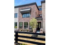 Beautiful brick home with large windows, a small tree, and black trim accents throughout the exterior at 11896 Spring Mill Rd, Carmel, IN 46032