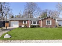 Charming brick ranch-style home featuring a well-manicured lawn and attached garage at 5890 Kingsley Dr, Indianapolis, IN 46220