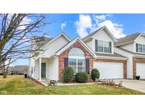 Charming two-story townhome boasts a brick facade, attached garage and well-maintained landscaping at 1463 Hamilton Dr, Greenwood, IN 46143