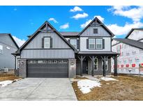 Two-story home showcasing gray siding, a two-car garage, brick accents and front porch columns at 20378 Hudson Bay Ln, Westfield, IN 46074