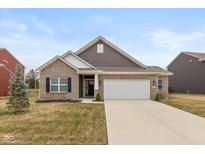 Charming single-story home features a brick facade, attached garage, and manicured front lawn at 8118 Ambrosia Ln, Pendleton, IN 46064