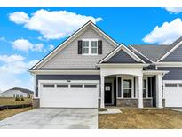 Charming two-story home featuring blue siding, a white garage door, and a covered front porch at 413 Onset Way, Westfield, IN 46074
