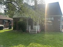 Charming brick home with awnings and a cozy front porch, perfect for relaxing in the neighborhood at 3305 N Keystone Ave, Indianapolis, IN 46218